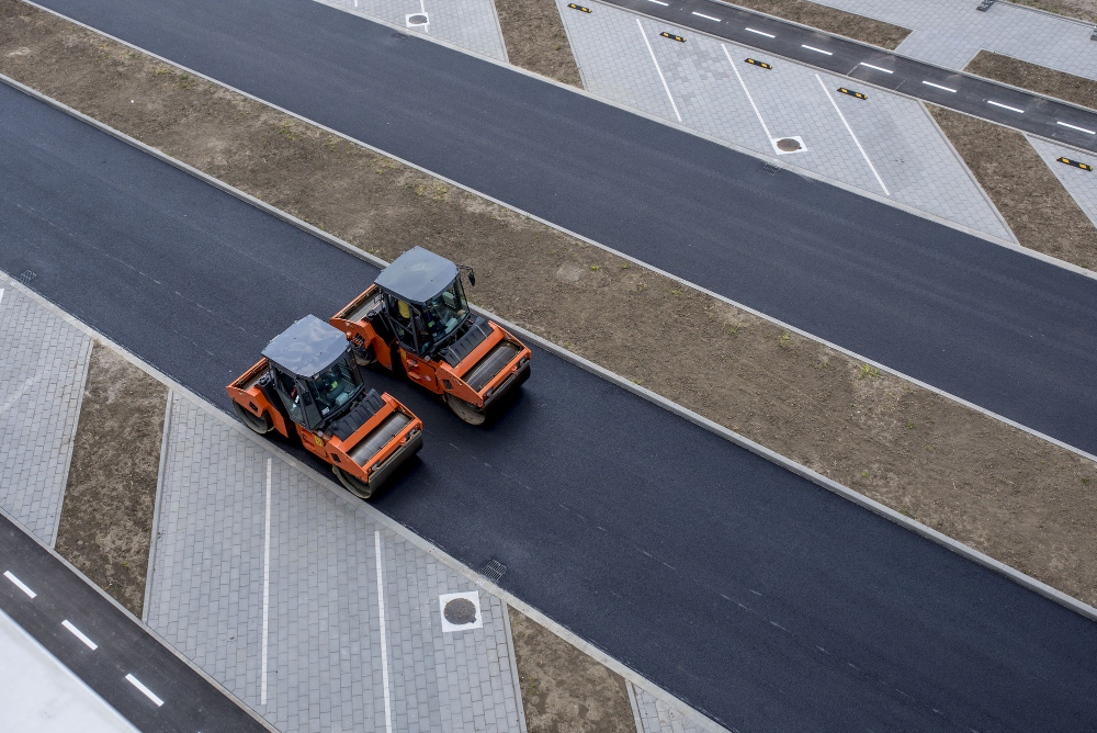 sky view of orange vibratory asphalt roller compactor on a new pavement
